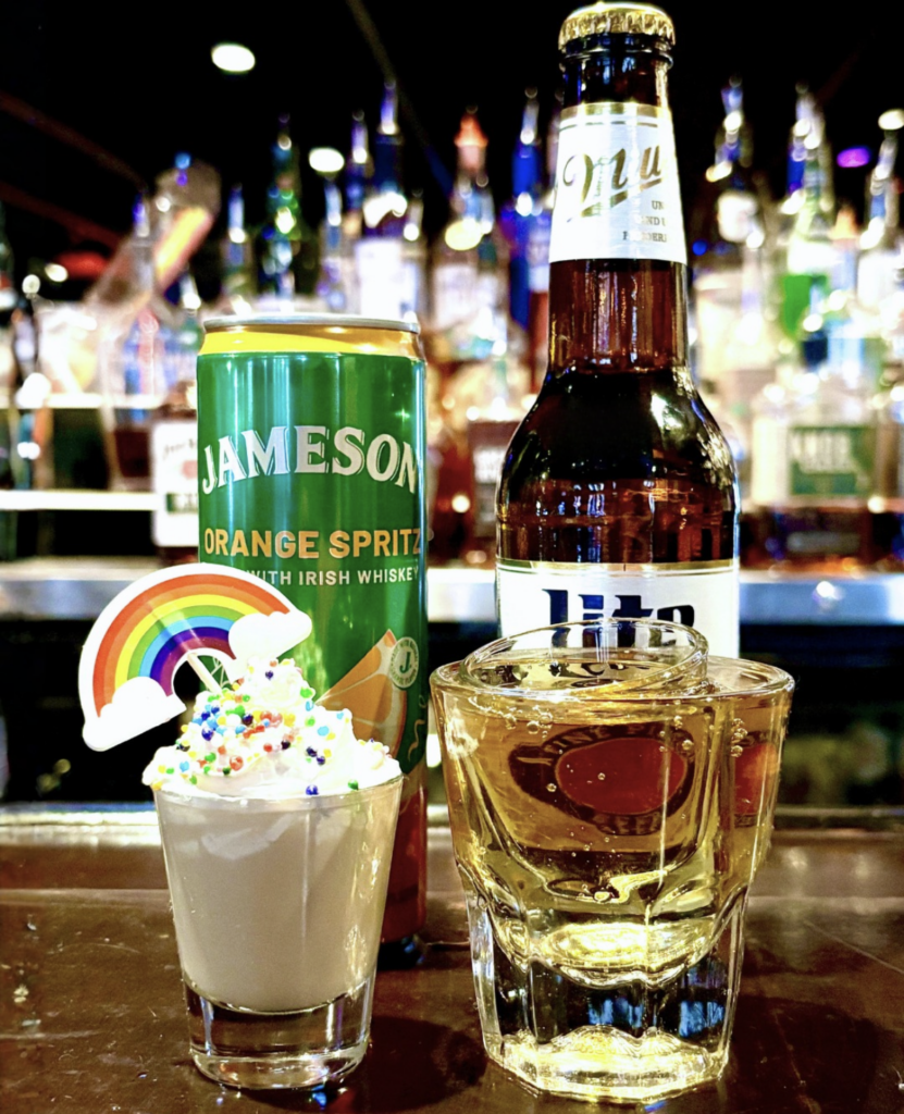 St. Patrick’s Day themed drinks at Howl at the Moon featuring a Jameson Orange Spritz can, Irish whiskey, and festive Lucky Charms shot with rainbow garnish at a live music bar.